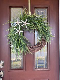 a wreath with starfishs hanging on the front door to decorate it for christmas