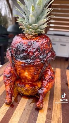 a pineapple is sitting on top of a chicken that has been grilled to look like a turkey