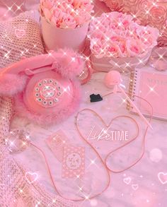 pink roses and other items on a white table cloth with sparkles in the background