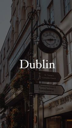 a street sign with the words dublin on it in front of a building and clock