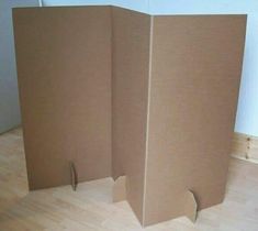 an open cardboard box sitting on top of a hard wood floor next to a wall