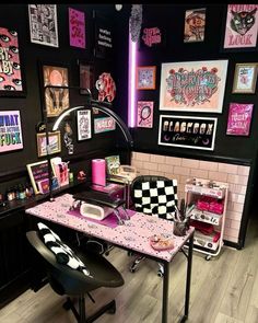 a pink and black desk with lots of pictures on the wall next to it in a room