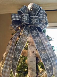 a christmas tree decorated with blue and white ribbon