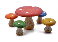 small wooden mushrooms with different colors and sizes on them, set against a white background