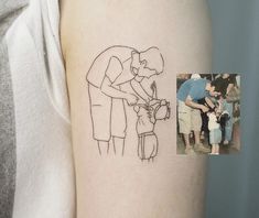 a person with a small tattoo on their arm is holding a child's hand