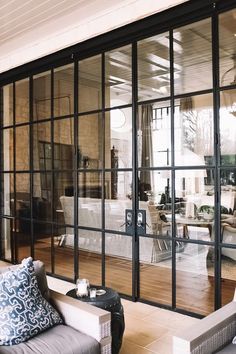 a living room filled with furniture and lots of glass doors that open up to the outside