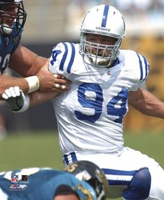 a football player holding the ball while being tackled by an opposing player in a game