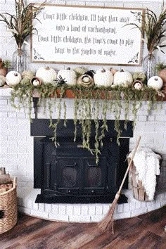 a fireplace decorated for fall with pumpkins and greenery