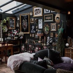 a living room filled with lots of furniture and pictures on the wall next to a table