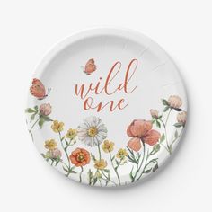 a paper plate with the words wild one painted in orange and white flowers on it