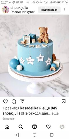 a blue cake with white stars and a teddy bear on top