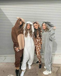 three girls in animal onesuits posing for the camera with one girl wearing a giraffe costume