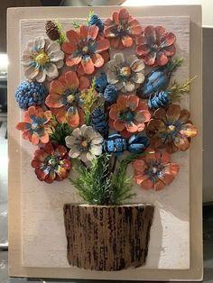 a vase filled with lots of flowers on top of a wooden table next to a wall