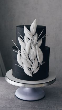 a black and white cake with leaves on top