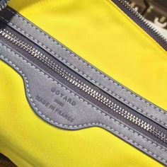 a yellow and grey bag with zippers on the inside is seen in close up