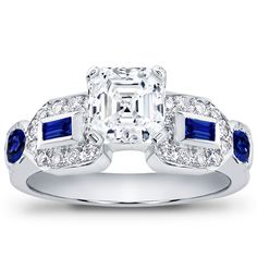 This diamond engagement ring is set with twenty-four round diamonds, two sapphire baguettes, and two round sapphires. This setting is available in white or yellow gold and platinum. Round Sapphire, Engagement Sets, Sapphire Engagement, Diamond Engagement Ring, Diamond Engagement, Round Diamonds, Diamond Engagement Rings, My Jewellery, Jewelry Box