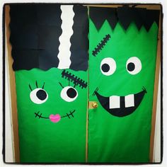 two green door decorated with monster faces