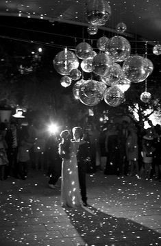 a bride and groom are standing under bubbles