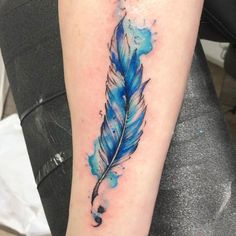 a blue feather tattoo on the arm