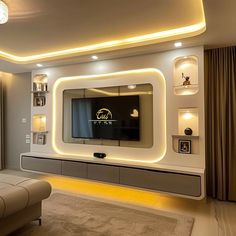 a modern living room with white furniture and lights on the wall, along with a large flat screen tv