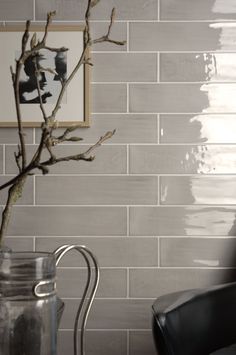 a black chair sitting in front of a white brick wall