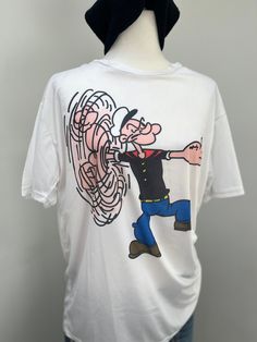 No labels. The nostalgic Popeye character print is vibrant and on both sides. Made of a polyester mesh fabric.  Everything I know (it's from the 90s) I was told from the previous owner in Quebec where I picked this from. Measures: 30" length and 43" chest 90s Style White T-shirt With Funny Print, 90s Style Crew Neck T-shirt With Character Print, 90s Style Character Print T-shirt, Affordable White Pop Culture T-shirt, 90s Short Sleeve T-shirt With Character Print, Popeye Japan Magazine, 90s Style Cotton T-shirt With Funny Print, White 90s T-shirt With Character Print, 90s Crew Neck T-shirt With Character Print