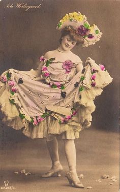 an old fashion photo of a woman in a dress with flowers on it's head