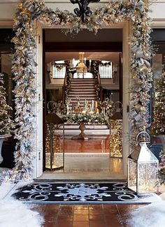 the front door is decorated for christmas with white and silver garlands on either side