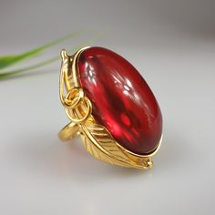 Amber ring. Ruby red Amber. Gold plated ring. This ring is adjustable. You can change size by pressing it. Very easy to do. Stunning red ring will be just the best gift for her. Gemstone size 3,5 × 2,4 cm. Weight 14,8 gr. This item was made of natural Baltic Amber. All the amber used in my jewelry is collected in my home country Lithuania. I sell only genuine, real, Baltic Amber. This is a yellow amber stone processed and paintedto make it look ruby red. Elegant Adjustable Gold Ruby Ring, Open Ruby Ring Gift, Elegant Handmade Gold Ruby Ring, Unique Gold Ruby Ring For Gift, Gift Ruby Cabochon Ring, Adjustable Gold Ruby Ring Gift, Cabochon Ruby Ring Gift, Gold Open Ruby Ring Gift, Gold Open Ring Ruby Ring Gift