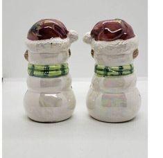 two ceramic salt and pepper shakers decorated with santa hats