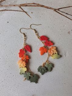 two pairs of earrings with leaves hanging from them