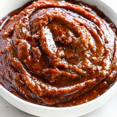 a white bowl filled with sauce on top of a table