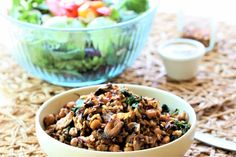 a bowl filled with food next to a salad