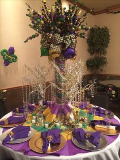 the table is set with purple, green and gold decorations