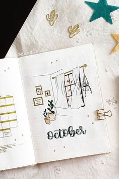 an open notebook with the words october written in cursive writing on it next to a pen and scissors