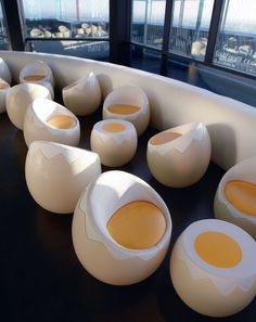 several egg shaped chairs in front of large windows