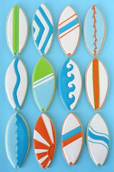 surfboard cookies are arranged in rows on a blue background