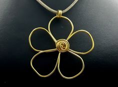 Striking simple funky gold flower pendant on a cord, hand made in the UK This bold eye-catching flower is made from coated aluminium and will be hand made to order so no two will be exactly identical! The pendant will be sent on a neutral colour faux suede cord but you could of course add it to your own chain later if you prefer. The cord has a gold coloured lobster clasp fastening. I will send this wrapped in tissue and in an organza bag so it would make a lovely gift for a special friend, or just treat yourself! Cord length is approximately 45cm plus 5cm extension chain  Pendant is approx 60mm across **Buy with confidence - I have a 14 day no-quibble returns policy on all my items** *FREE First Class shipping within the UK* I've got lots of other lovely things in my shop, including this Flower Pendant Necklace With Adjustable Cord, Gold Metal Flower Necklace As Gift, Handmade Gold Necklace With Flower Pendant, Handmade Gold Flower Necklace, Unique Gold Jewelry With Flower Charm, Big Gold Necklace, Gold Flower Necklace, Poppy Necklace, Jewellery For Women