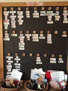 two baskets filled with books sitting on top of a table next to a blackboard