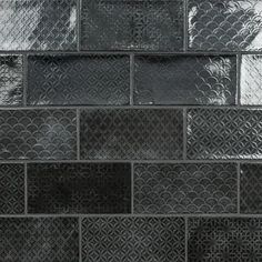 a black and white photo of a wall made out of metal squares with circles on them