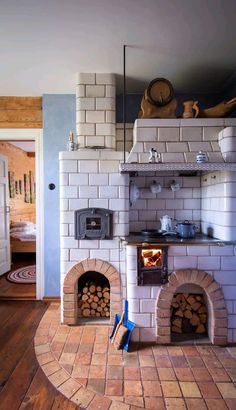 a brick oven sitting inside of a kitchen next to a stove top oven with logs in it