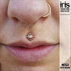 a woman's nose with a gold nose ring and an ophtia piercing