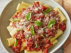 a bowl filled with pasta and sauce covered in parmesan cheese