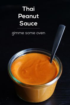 an orange sauce in a glass jar with a spoon