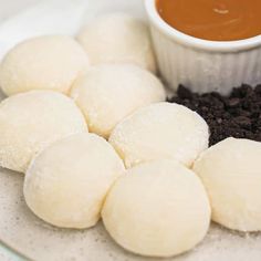 some food is sitting on a plate with dipping sauce