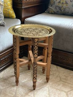 a wooden table sitting on top of a floor next to a bed