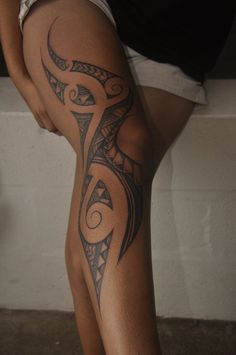 a woman's leg with an intricate tattoo design on the lower part of her thigh