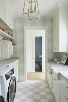 a washer and dryer are in the middle of a kitchen with checkered flooring