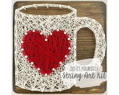 a string art kit with a red heart in the shape of a mug on top of a wooden table