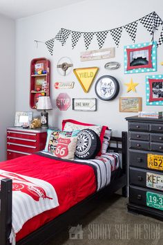 a bedroom decorated in red, white and blue with lots of pictures on the wall